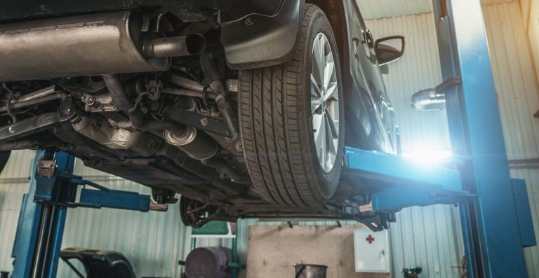 Underneath of a car raised up of the ground ready for an MOT test